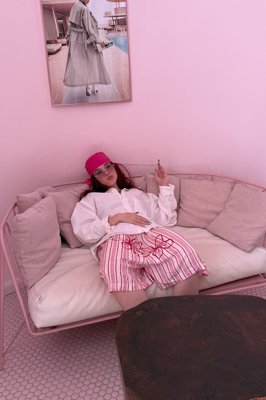 Modelo en un salón rosa con la camisa blanca All day long, long bóxers Stop blooming rojos y la bandana Many ways rosa anudada a la cabeza