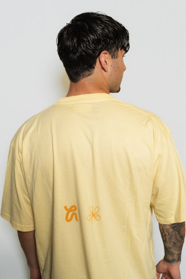 Espalda de la camiseta Love Generation con la flor de Blooma y el logo de Hippy House